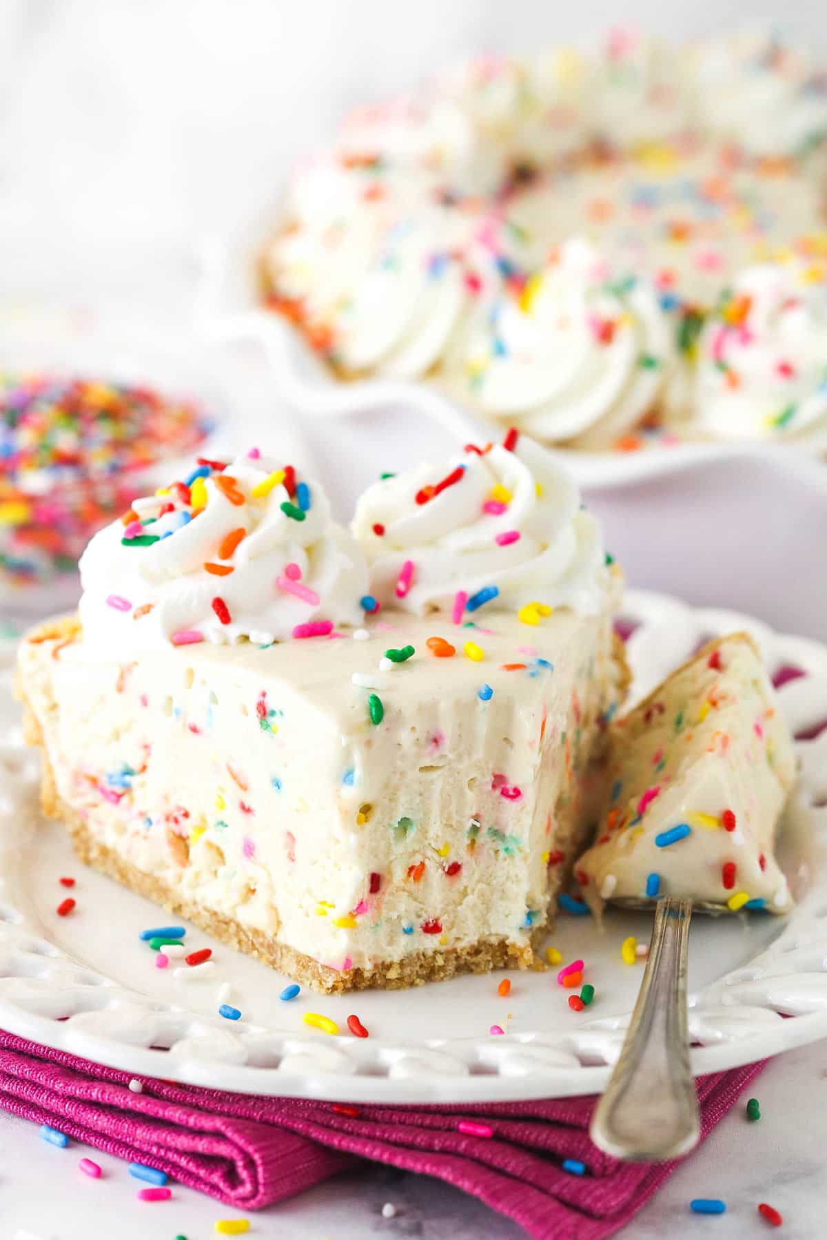 slice of cake batter ice cream pie on white plate with a bit taken out