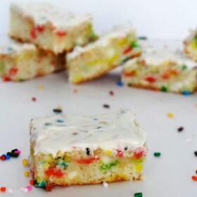 A Funfetti Blondie with icing surrounded by sprinkles