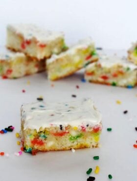 A Funfetti Blondie with icing surrounded by sprinkles