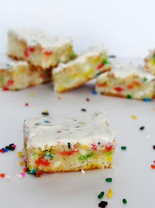 Funfetti Cake Batter Blondies with Rainbow Chip Icing A Funfetti Blondie with icing surrounded by sprinkles