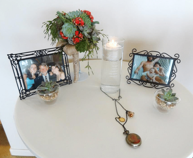 A Table with Two of Janelle's Family Photos, A Candle and a Few Family Heirlooms of her Late Father's