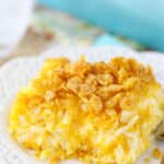 Plate of cheesy hashbrown casserole with crushed cornflakes.
