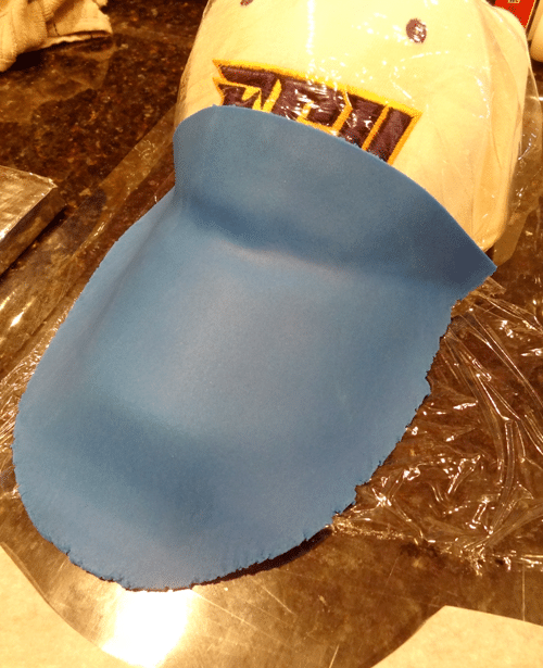 Shaping Blue Fondant Around the Brim of a Baseball Cap