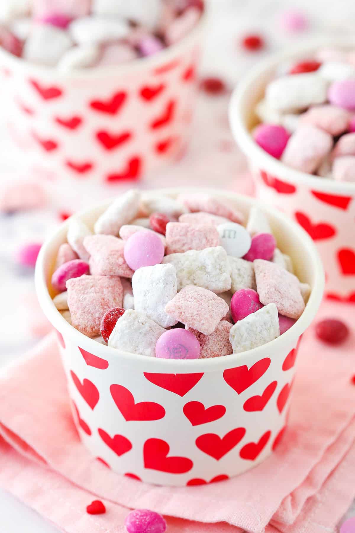 strwaberries and cream puppy chow in heart covered paper bowl
