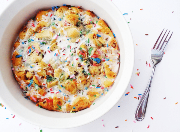 Funfetti Cake Batter Cinnamon Roll Casserole in a white baking dish next to a fork