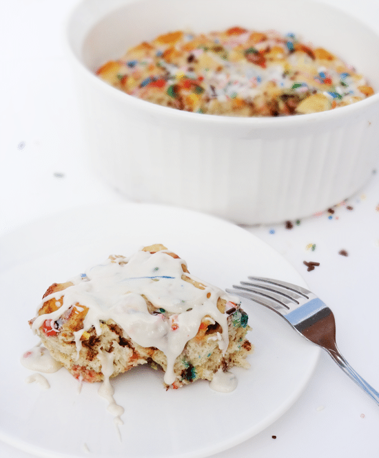 Funfetti Cake Batter Cinnamon Roll Casserole single serving on white plate with casserole in background