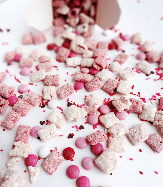 Strawberries and Cream Puppy Chow on white surface with take out container in background