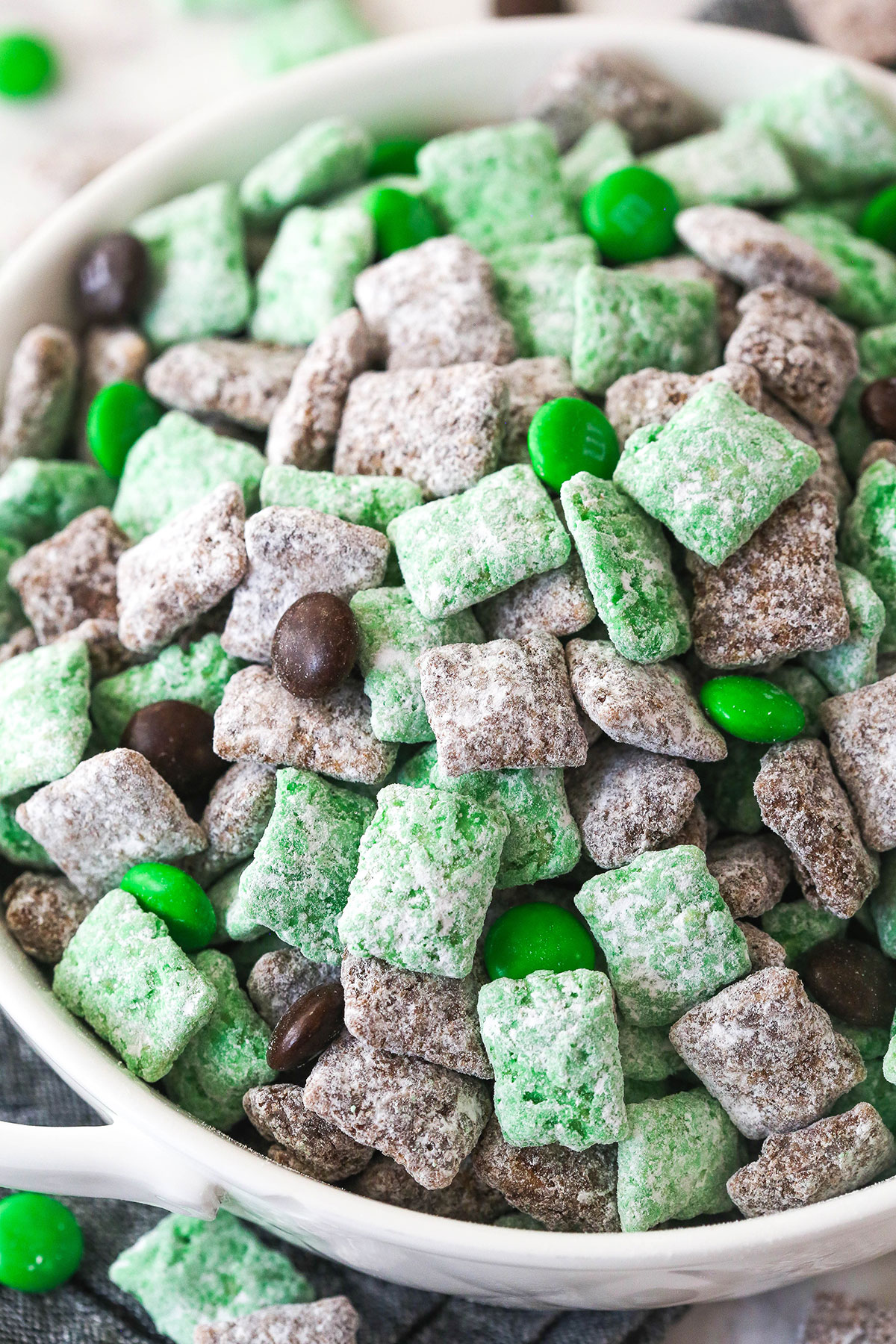 close up of baileys puppy chow in white bowl on grey napkin