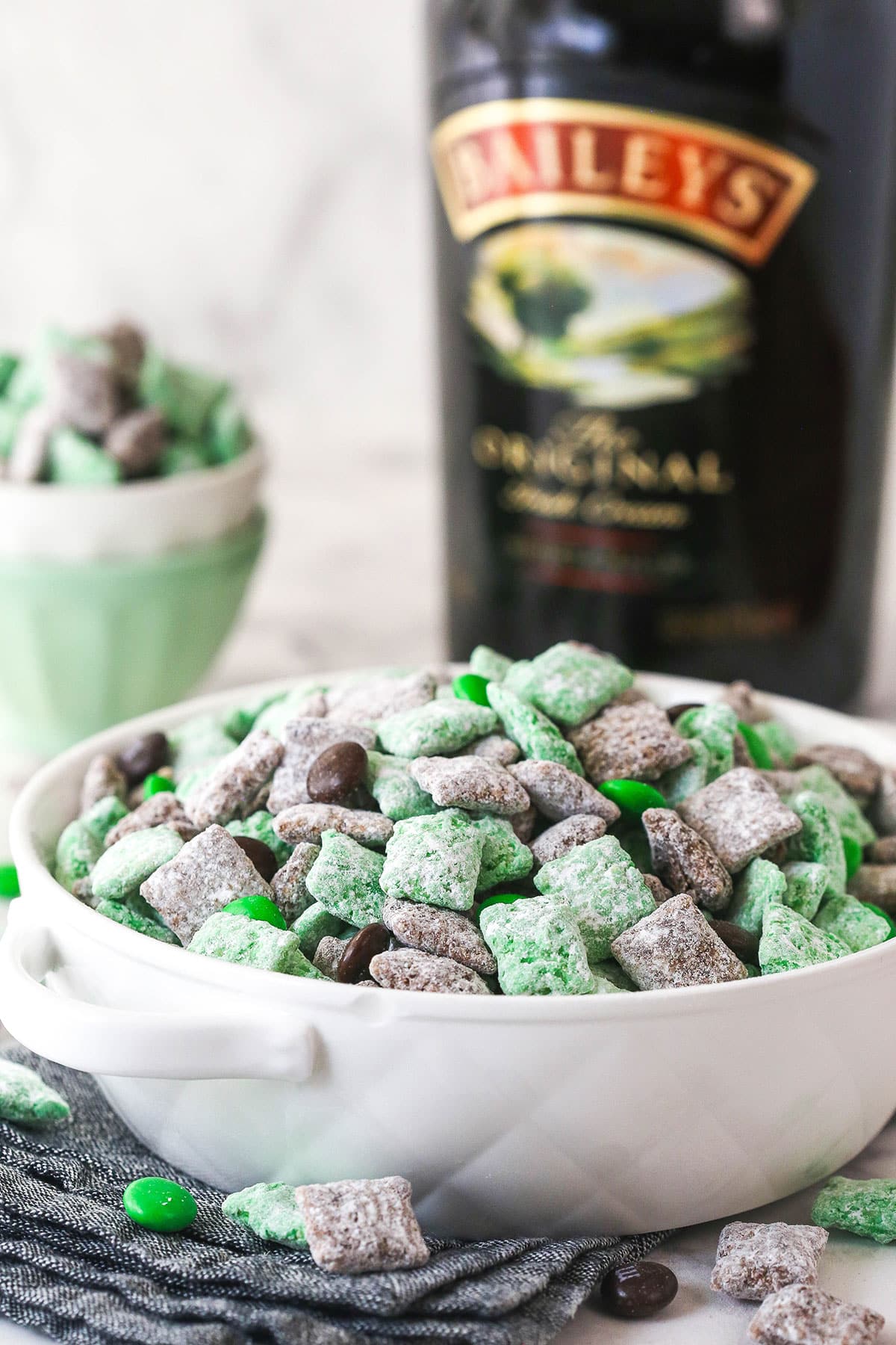 baileys puppy chow in white bowl with bottle of baileys in the background