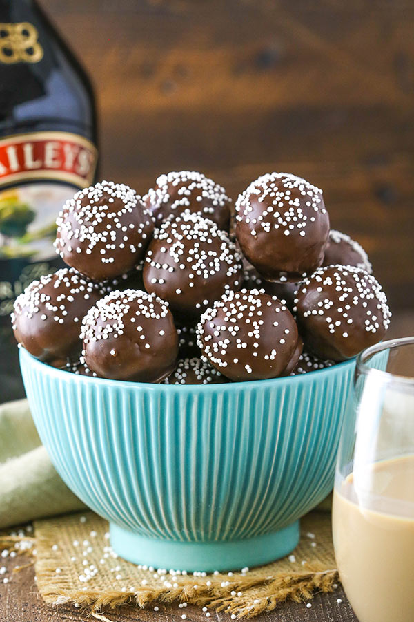 A large teal bowl overflowing with Baileys cookie balls topped with sprinkles