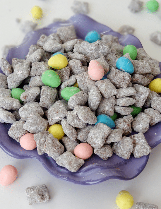 Muddy Buddies in purple bowl with Reese's Easter eggs