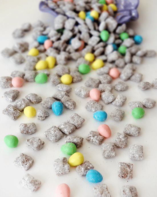 Muddy Buddies and Reese's Easter Eggs spilled out on a white surface