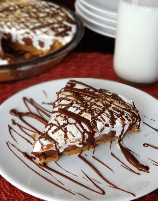 A slice of Peanut Butter Nutella and Marshmallow Pie on a white plate and drizzled with chocolate