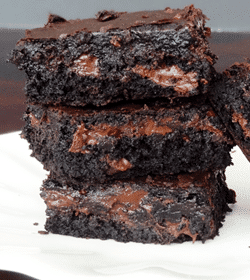 Brownies stacked on white plate