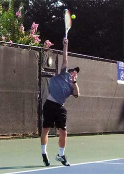 Ian serving a tennis ball. Love our family life.