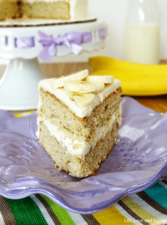 A close-up shot of a slice of double-layer cake with vanilla buttercream frosting