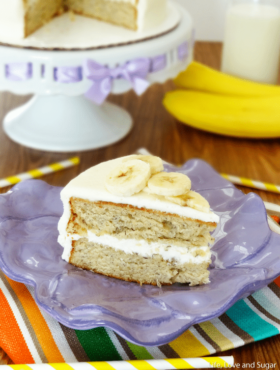 A piece of banana cake on a clay plate with the remaining cake behind it