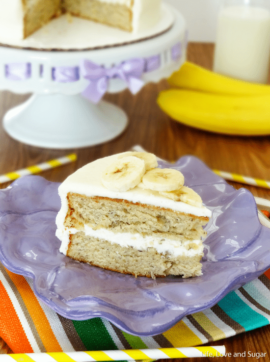 A piece of banana cake on a clay plate with the remaining cake behind it