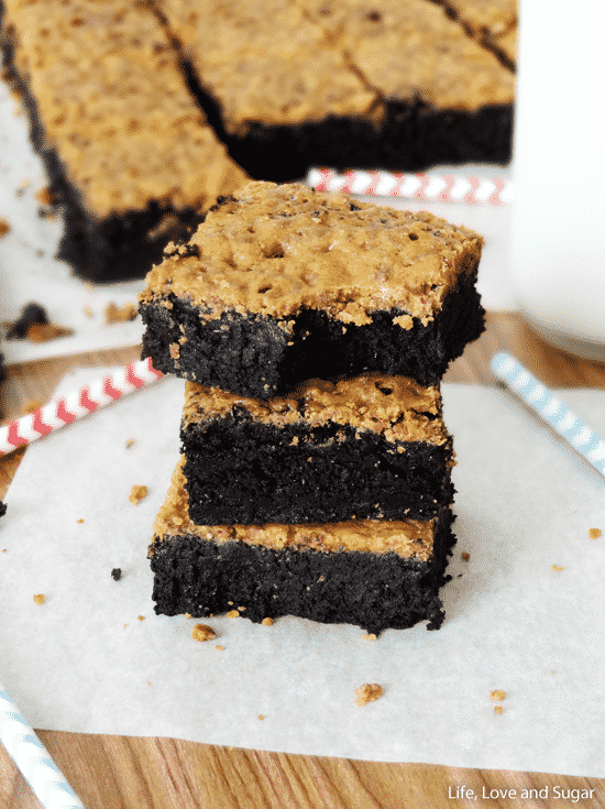 Three brownies stacked with the top brownie missing a bite