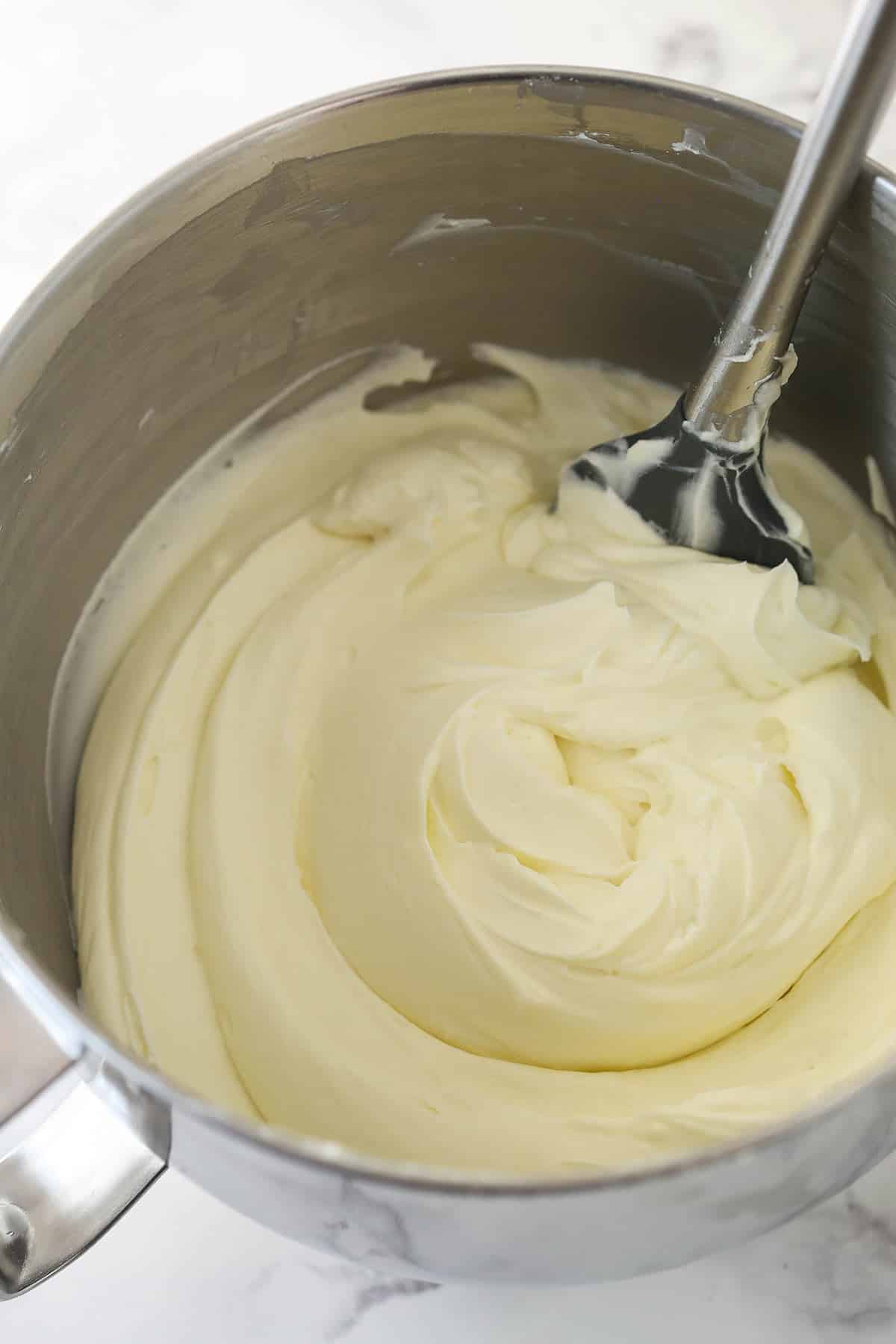 Making cheesecake filling for a no bake oreo cheesecake in a metal stand mixer bowl