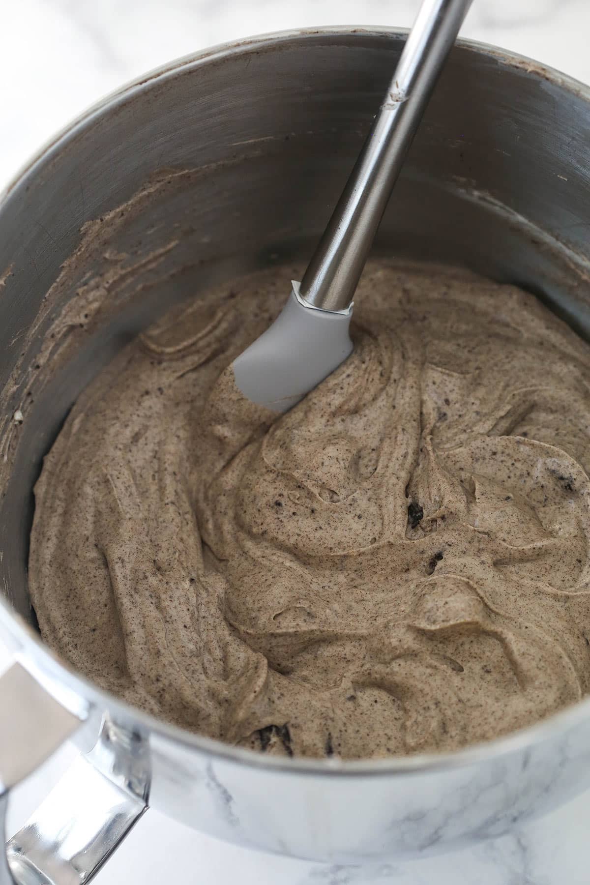 Oreo cookie crumbs mixed into the cheesecake filling in a stand mixer bowl