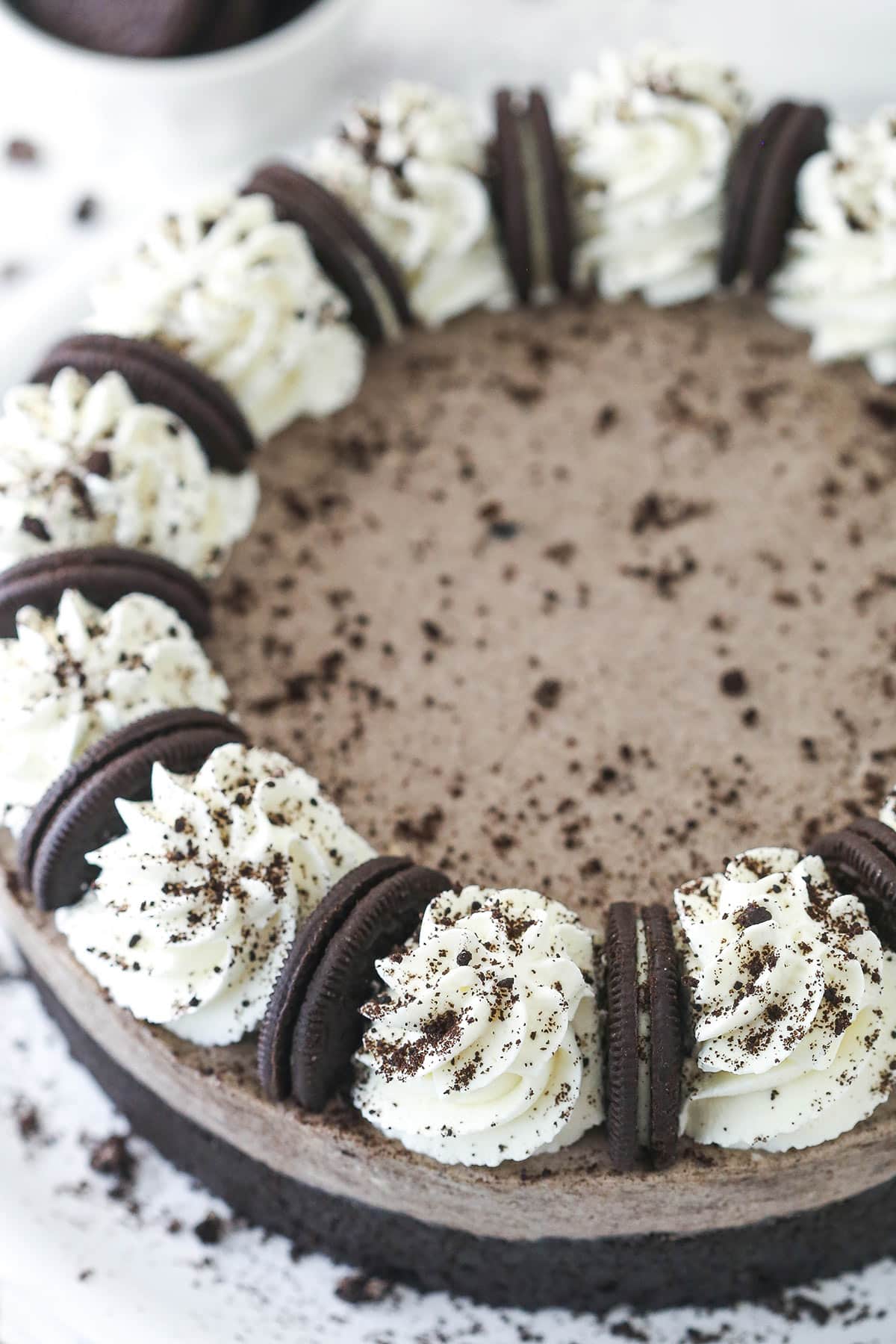 Top view of a no bake oreo cheesecake decorated with whipped cream and cookies