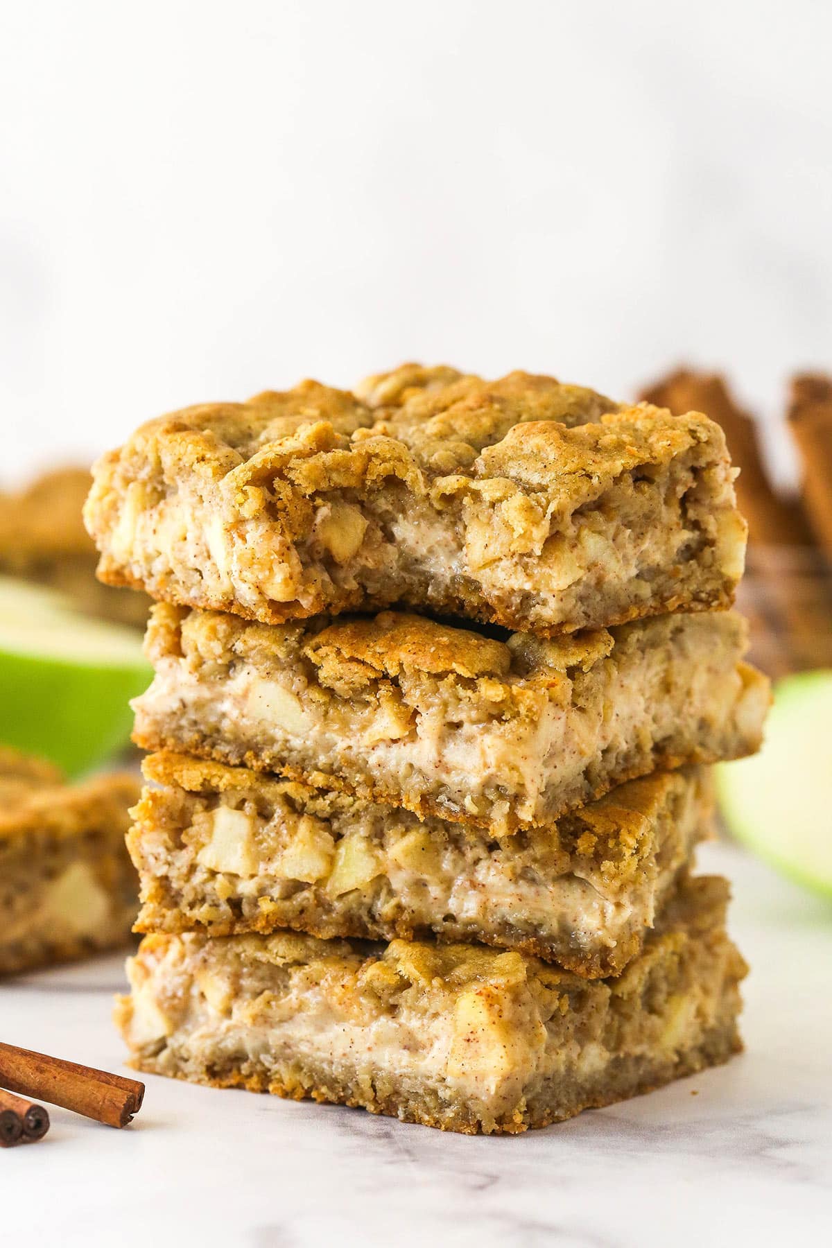 With layers of chewy oatmeal cookies, cheesecake filling, and cinnamon apples, these Apple Cheesecake Oatmeal Cookie Bars are for fall. A stack of apple cheesecake oatmeal cookie bars
