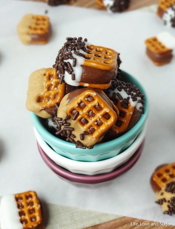 Chocolate Covered Nutella Pretzel Bites piled in colorful stacked bowls