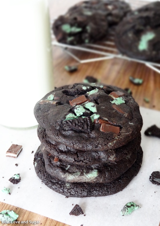 Mint Chocolate Cookies stacked on white paper near a glass of milk
