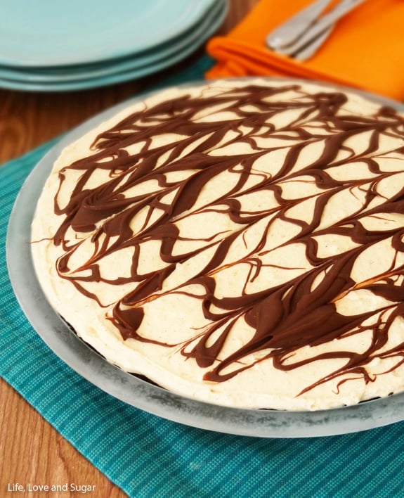 A pumpkin spice icebox pie in a pie plate on top of a striped kitchen towel