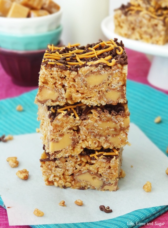 Three square Caramel Rolo Rice Krispie Treats stacked tall on a white paper