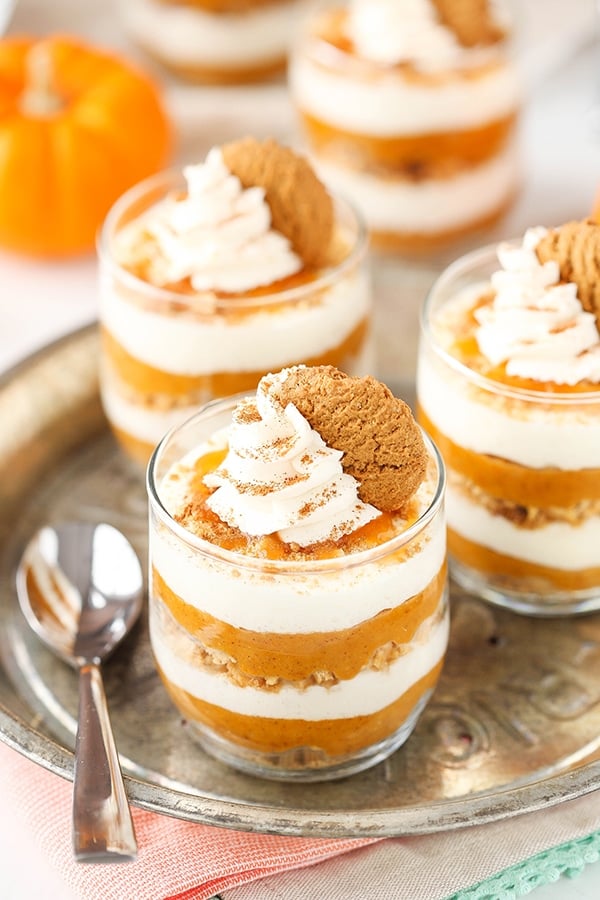 Three mini pumpkin pies on a metal serving platter with a spoon