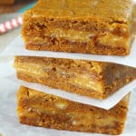 Gingerbread Caramel Gooey Bars stacked on wax paper