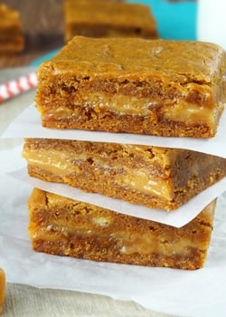 Gingerbread Caramel Gooey Bars stacked on wax paper