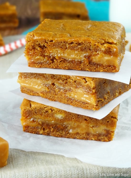 A close up of Gingerbread Caramel Gooey Bars stacked on top of each other