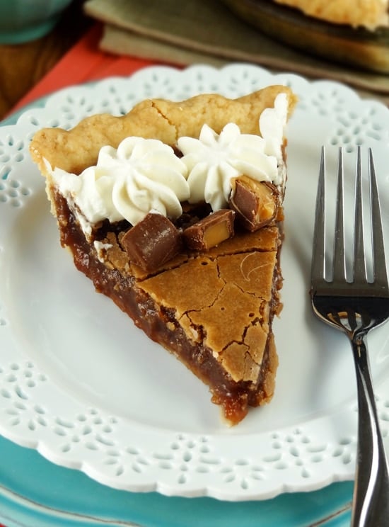 A fork and slice of chess pie sit on a white decorative plate