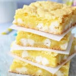 Lemon White Chocolate Gooey Bars stacked on wax paper