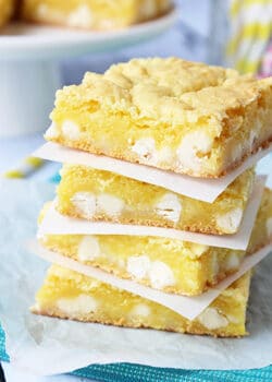 Lemon White Chocolate Gooey Bars stacked on wax paper