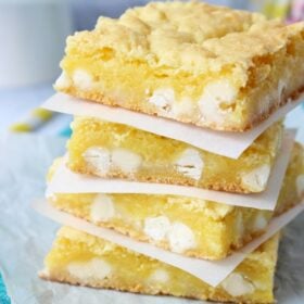 Lemon White Chocolate Gooey Bars stacked on white plate