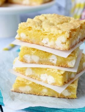 Lemon White Chocolate Gooey Bars stacked on white plate