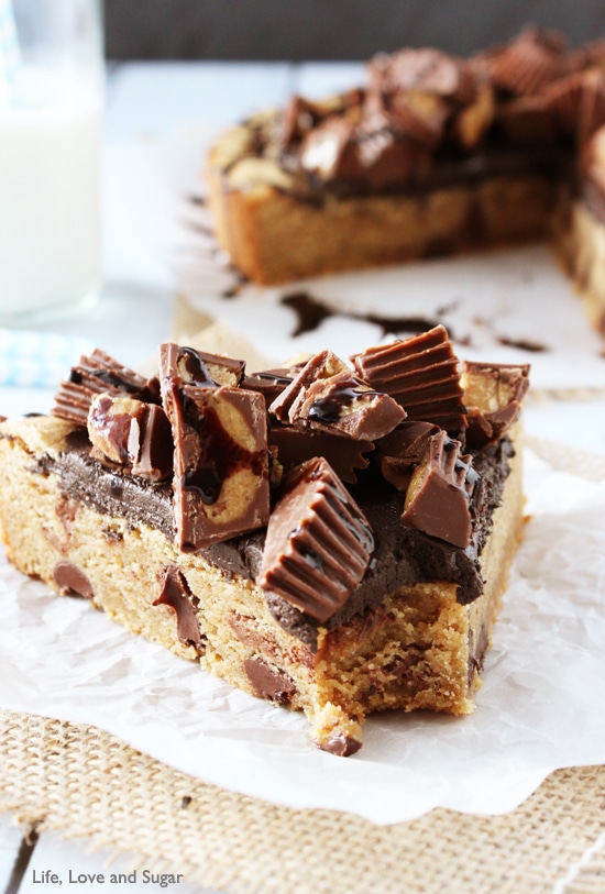 A slice of Reese's Peanut Butter Chocolate Chip Cookie Cake with a bite removed