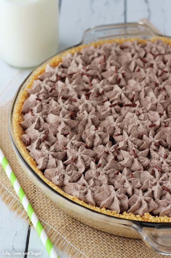 A whipped cream topped Chocolate Pie in a glass pie dish