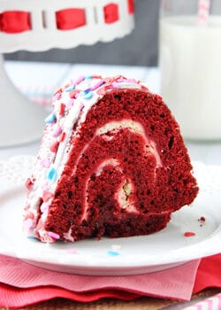 A slice of Layered Red Velvet Cheesecake Bundt Cake on a white plate