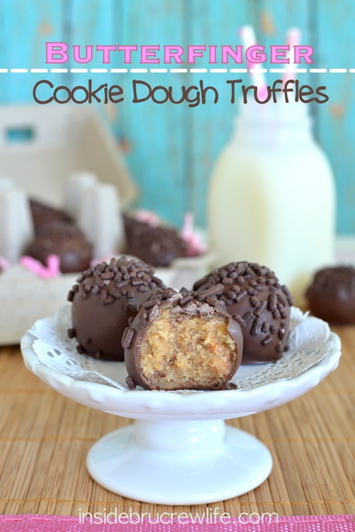 Three Butterfinger Cookie Dough Truffles on a small white serving cake plate.