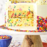 Funfetti millionaire cake with a slice cut out to show the layers