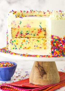 Funfetti millionaire cake with a slice cut out to show the layers