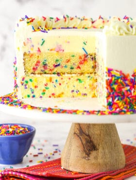 Funfetti millionaire cake with a slice cut out to show the layers