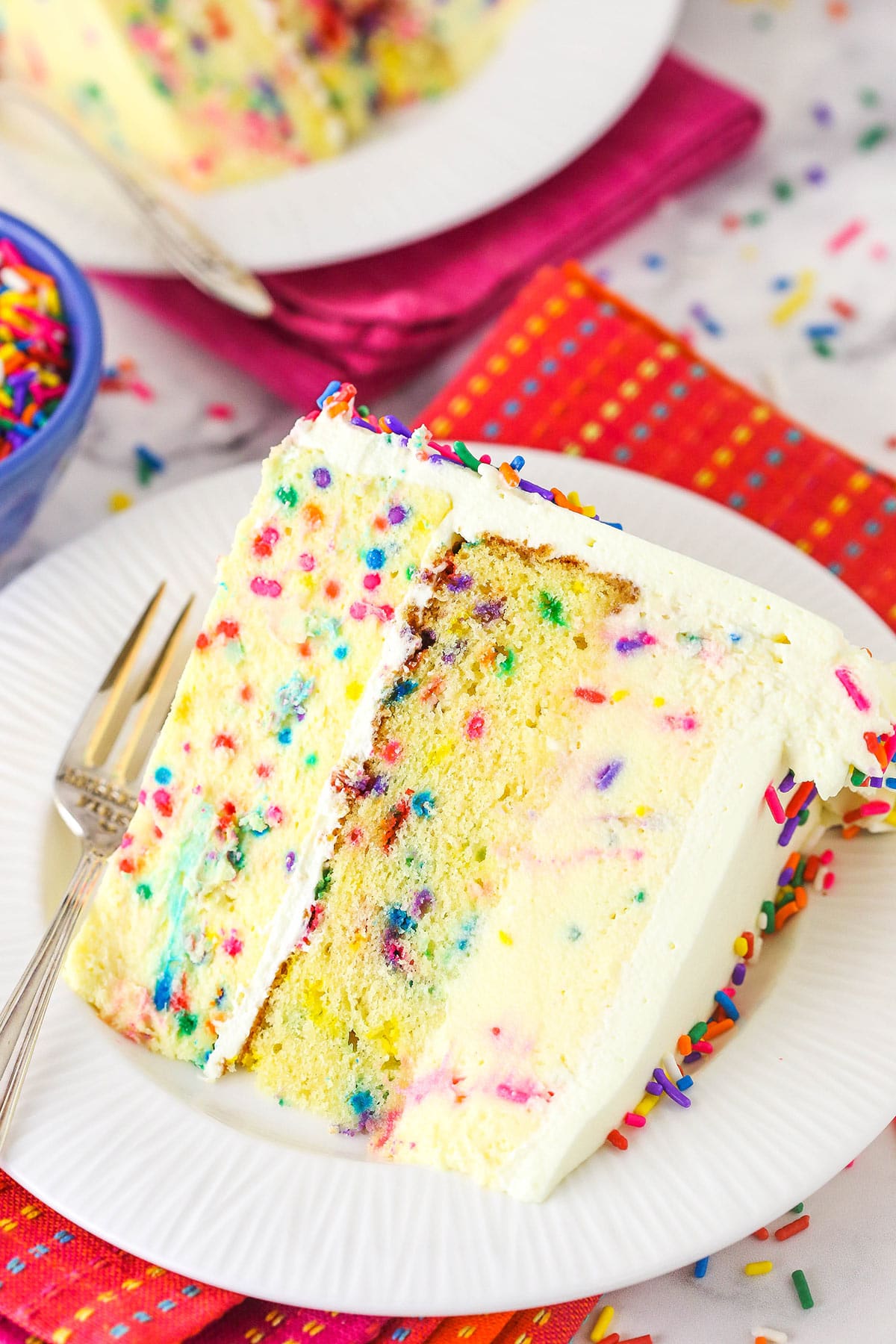 A slice of funfetti millionaire cake on a whit eplate