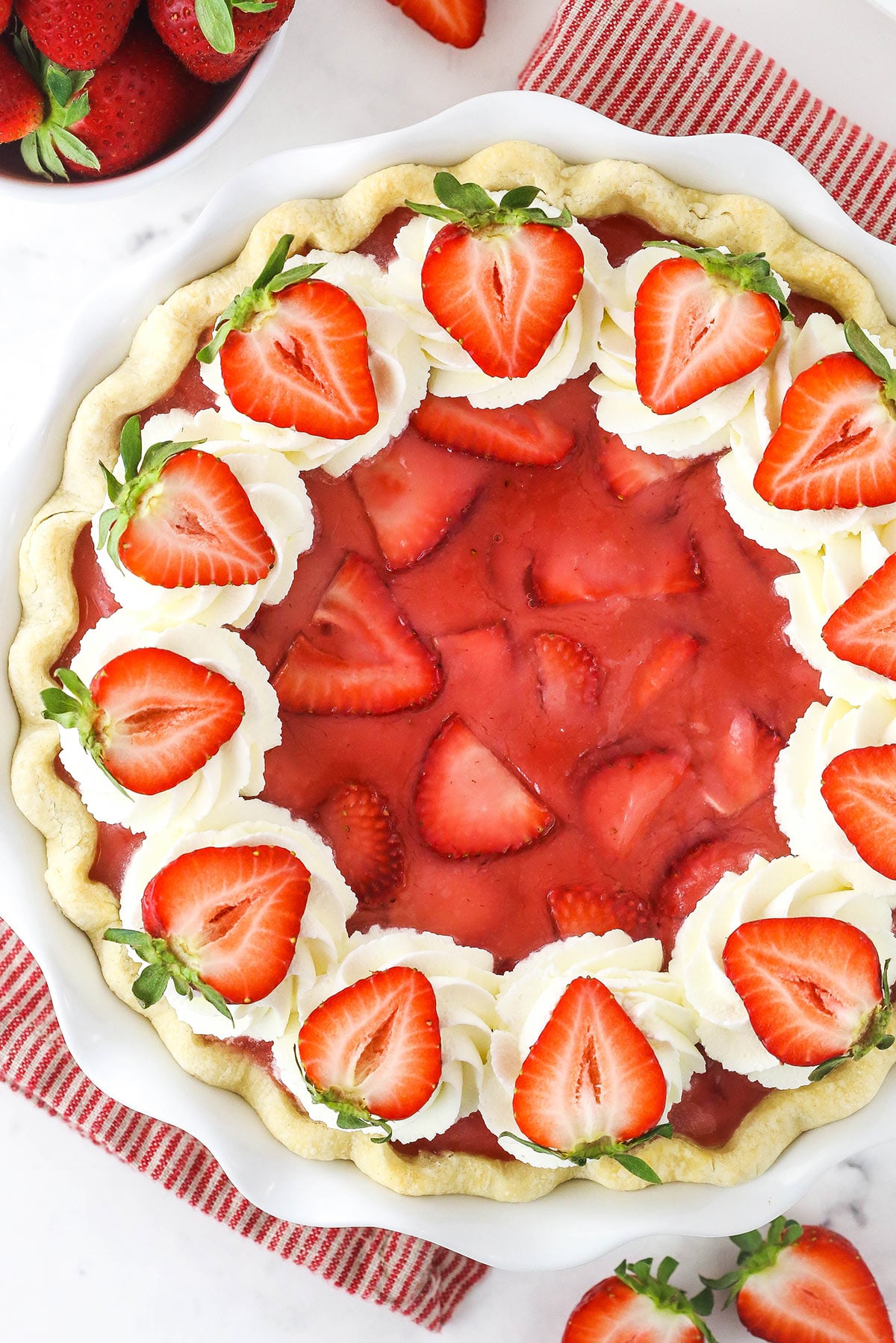 A fresh strawberry pie topped with halved strawberries shown from above