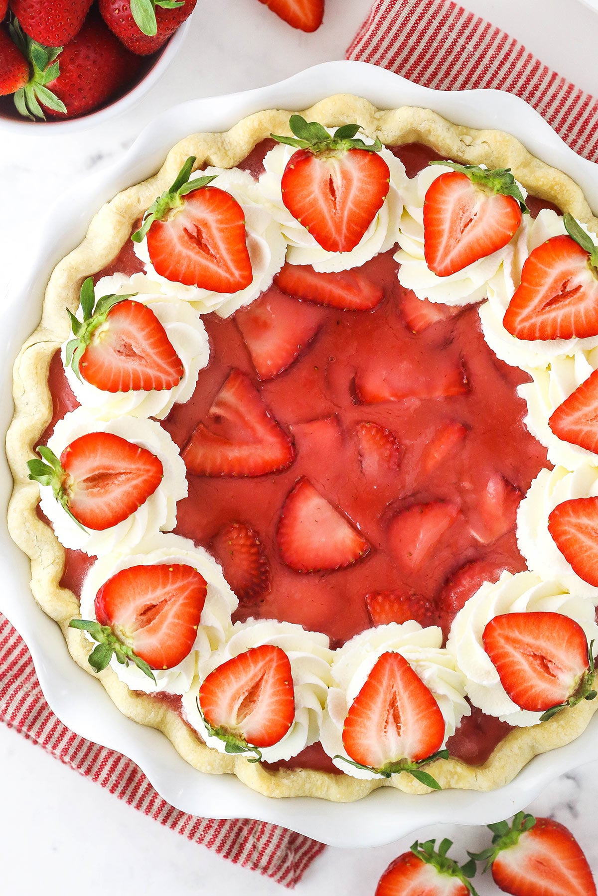 A fresh strawberry pie topped with halved strawberries shown from above